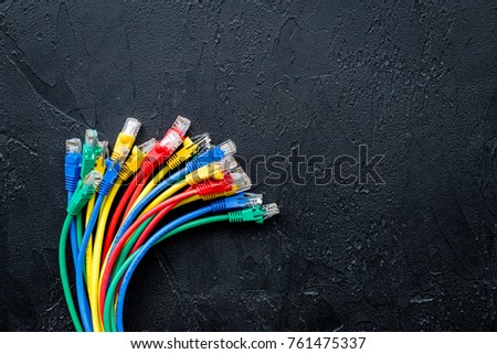 Network wires assorted colors with tips on black background top view copyspace