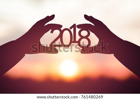 Silhouette 2018 in businessman hand. Background sunrise Royalty-Free Stock Photo #761480269