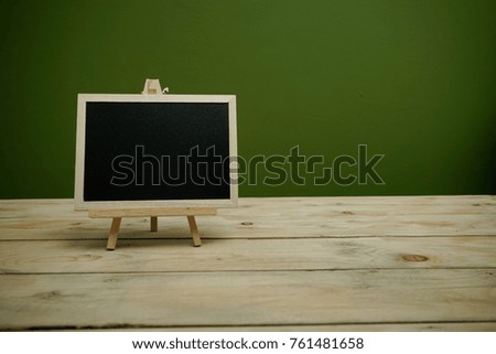 Blank chalkboard as copy space for your custom text on a wooden table.