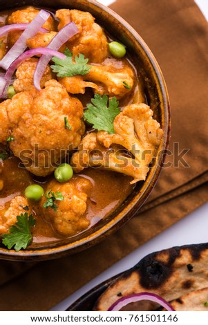 Aloo Gobi matar is a famous Indian curry dish with potatoes and cauliflower and green peas, selective focus
