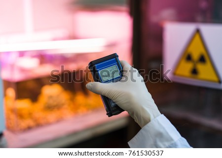Radiation supervisor in glove with geiger counter checks the level of radiation in the radioactive zone Royalty-Free Stock Photo #761530537