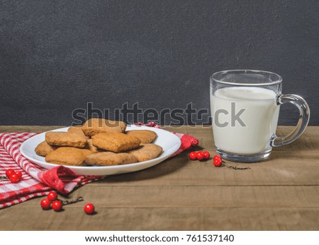 Biscuits, milk, red napkin, Christmas decor with free space for text.