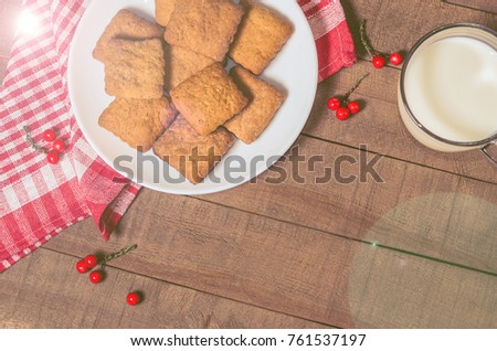 Biscuits, milk, red napkin, Christmas decor with free space for text. Top view
