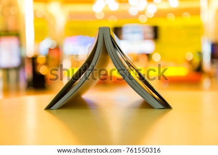 Upside down opened book on blurred warm background