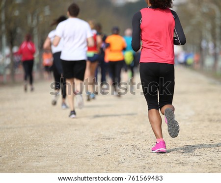 footrace with many athletes and an young african girl that runs fast Royalty-Free Stock Photo #761569483