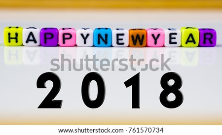 Colourful alphabetical cube arranged in word HAPPY NEW YEAR isolated over white background. Selective Focus.