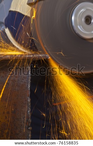 A man working with grinder, close up on tool, sparks fly, real situation picture