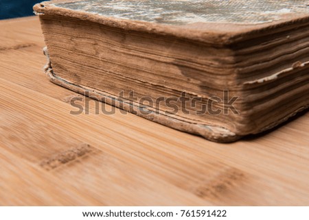 old book open on a wooden table with glasses