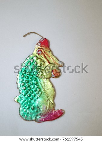 Christmas toy, old cardboard toy, cartoon character green crocodile in a red hat with a handset