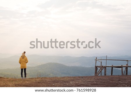 Women with yellow sweater with the mountain, sky, lonely felling and fresh air in winter, this image can use for wallpaper/background