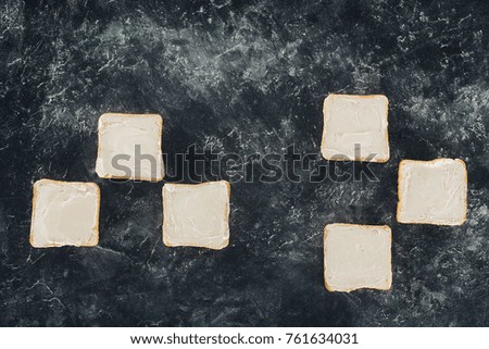 top view of fresh healthy toasts with butter on black slate board