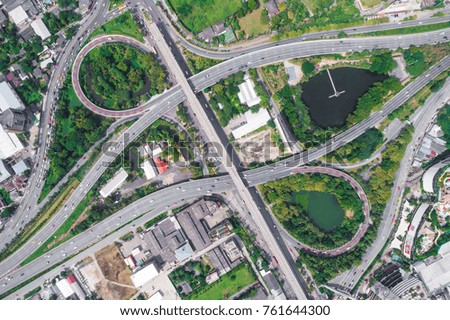 Expressway traffic circle road with car and green tree pond look down view