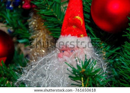 New Year's toy Santa Claus under a tree in a festive tinsel close up
