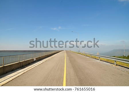 Long and empty, no ending road with blue sky background. 