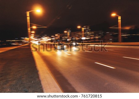 The car is driving along the road. Long exposure. Blurred background