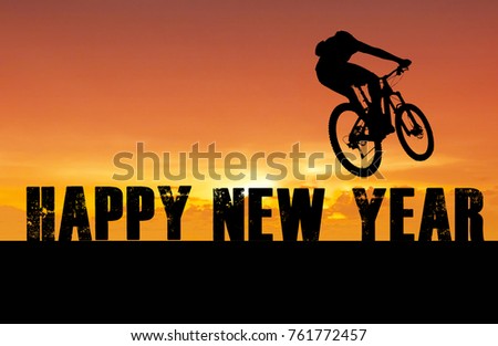 Happy new year 2018 silhouette a man Mountain bike ride On the letter Happy New Year at sunset time