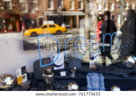 Neon sign saying "Dream" hanging in a Manhattan storefront window.