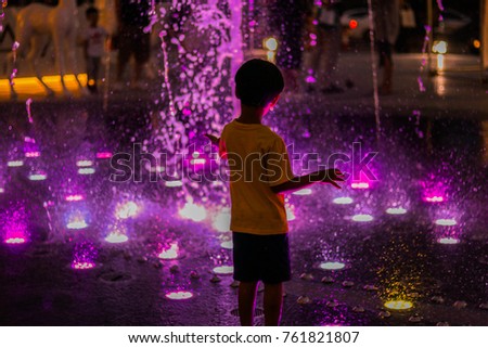 Young boy play fountain have colorful in front of shopping mall 