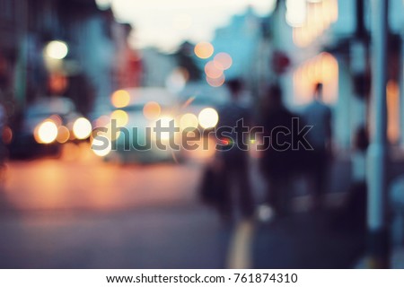 Blurred people walking through a city street