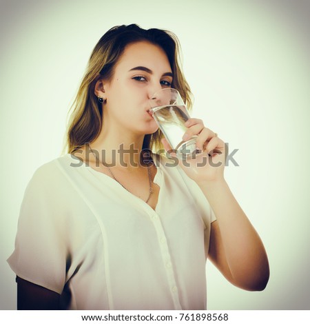 Young pretty girl drinks fresh water, studio