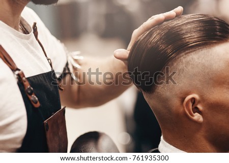 Close-up of barber shop does haircut undercut for man. Concept barbershop. Soft focus. Royalty-Free Stock Photo #761935300