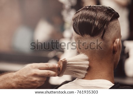 Close-up of barber shop does haircut undercut for man. Concept barbershop. Soft focus. Royalty-Free Stock Photo #761935303