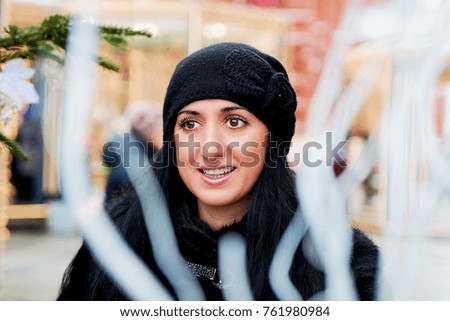 close-up portrait of a beautiful brunette girl in winter at Christmas on the street