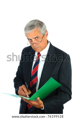 Portrait of a serious middle aged business man writing in a file folder. Vertical format isolated on white.