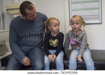 twins in anticipation of a doctor, three-year-old girls at a doctor's appointment