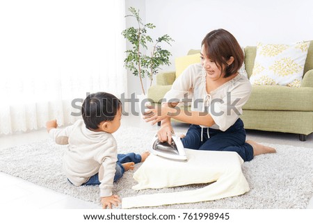 Mother doing household chores and child