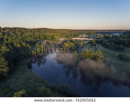Aerial view over Merkys river valley, near Merkine town, Lithuania. During sunny summer season, surrounded by pine tree forest.
