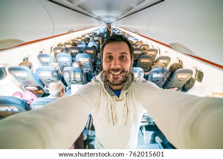 Handsome man in holiday take selfie photo on the air plane during flight around the world
