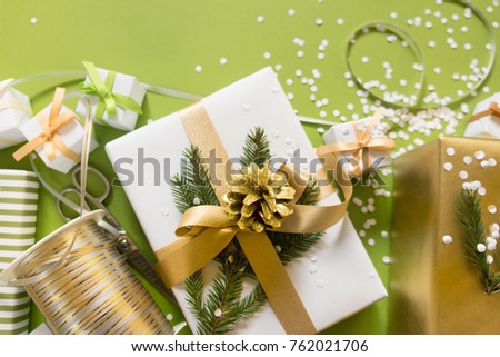 Top view of a white gift with a gold ribbon, a cone and a snowflake. A bow on a gift.