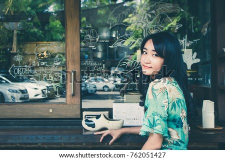 Beautiful Asian woman smiling in outdoor scene, vintage tone