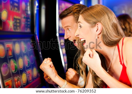 Couple in Casino on a slot machine Royalty-Free Stock Photo #76209352