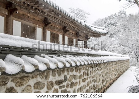 Snow covered Korean traditional stone wall and roof tile
