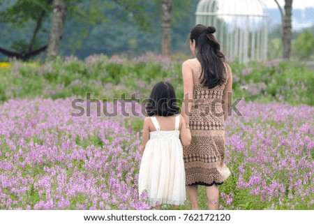 Portrait of mother and child playing with flowers at sunset