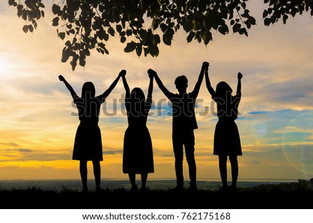 Silhouette people holding hands at sunset background