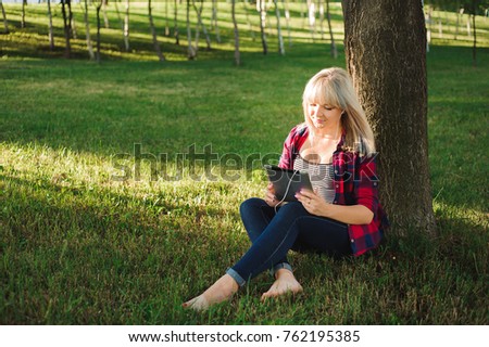 Portrait of young beautiful smiling woman with tablet pc, outdoors