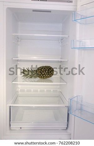 Pineapple inside in empty clean refrigerator with opened door