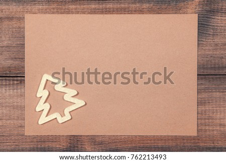Christmas and New year background. A sheet of vintage paper with decorative elements on wooden surface. Empty space for your message.