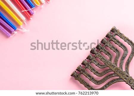 Colorful candles and menorah (candelabrum) symbols Jewish holiday Hanukkah on pink background.Top view.Flat lay.Copy space.