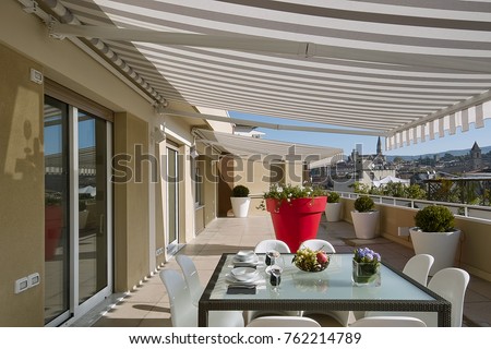 exteriors shots with the foreground glass dining table with plates and a bunch of grapes