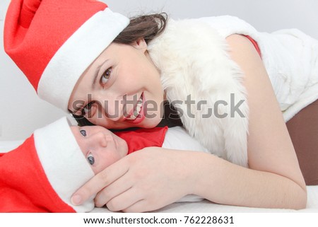 Photo of the Happy mother with male baby wearing christmas hats