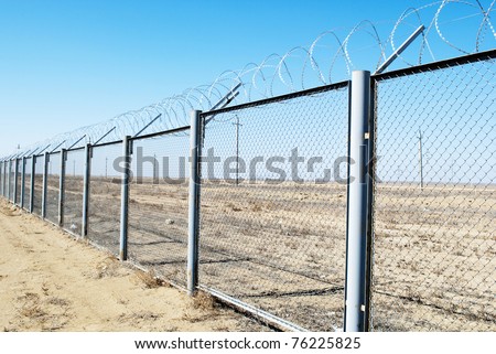 Fence with barbed wire on a background of blue sky