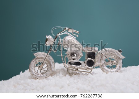 Christmas card. A small motorcycle in the snow. New Year's greeting card, close-up. Congratulation for a motorcyclist. Christmas toys and decor. christmas tree branch