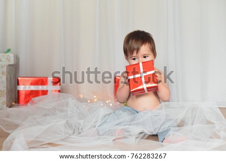 Happy baby and New Year's decoration. Baby with gifts