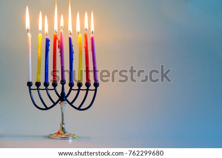  Image of Jewish holiday Hanukkah background with menorah (traditional candelabra) and burning colorful candles .Copy space for text.