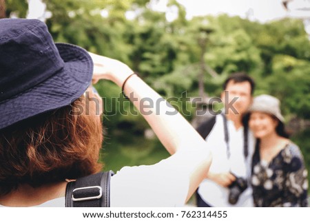 blur image of a tourist couple captured picture by a woman with blue hat