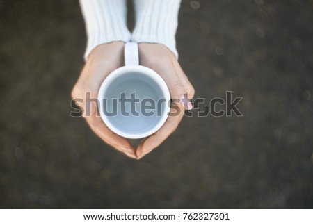 Female hands holding cups of coffee.